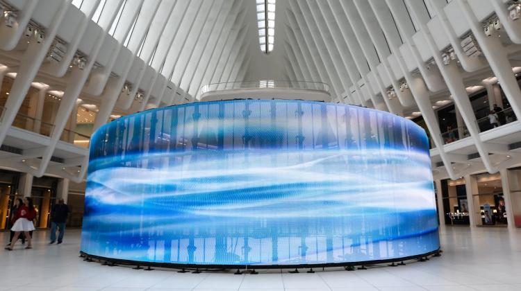 A blue art installation in a white windowed lobby.